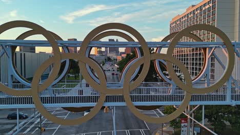 Atlanta-Olympic-Cauldron-Tower-Mit-Blick-Auf-Wolkenkratzer-Und-Gebäude-Im-Hintergrund,-Historisches-Schild-Der-Olympischen-Spiele,-Georgia,-USA