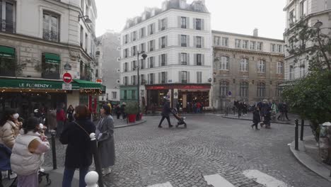 Public-central-city-street,-people-walking-around-square-in-Paris,-wide-shot