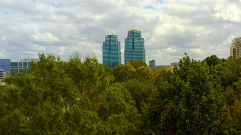 Aerial-shot-slowly-rising-above-the-trees-to-reveal-the-King-and-Queen-towers-in-Atlanta