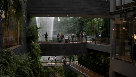 Besucher-Sahen,-Wie-Sie-In-Zeitlupe-Den-Atemberaubenden-Indoor-Wasserfall-Sahen,-Der-Am-Flughafen-Jewel-Changi-Herabstürzte
