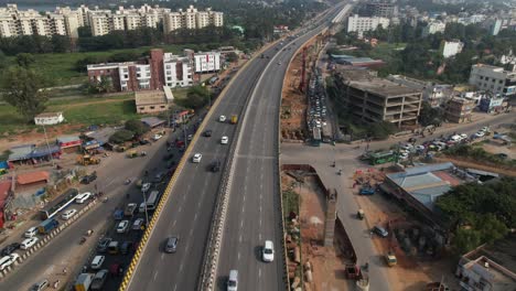 Indian-Highway-is-a-cinmatic-aerial-footage-of-rapidly-moving-cars-and-the-construction-of-a-metro-train-bridge-visible-above-the-service-roads