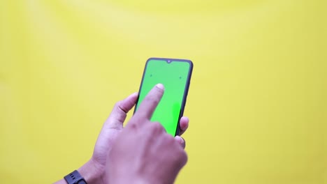 Close-Up-studio-Shot-of-man-Hand-Holding-his-Smartphone-with-Green-Screen,-shifting,-Touching-Screen