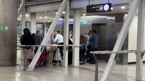 Passengers-are-waiting-to-use-elevator-lift-in-Iran-Tehran-Khomeini-IKA-airport-in-middle-east-Asia-there-was-a-missile-attack-to-Ukraine-flight-from-military-forces-when-people-in-departure-flight