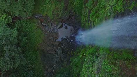 Fresh-water-falls-down-waterfall-in-wet-valley,-tropical-rainforest,-aerial