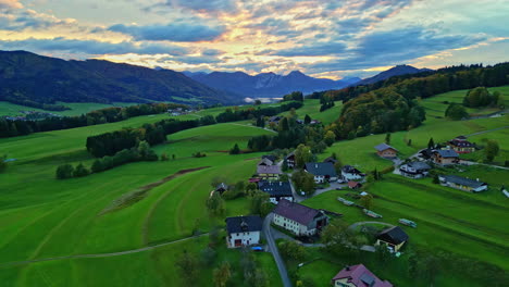 Malerisches-Europäisches-Dorf,-Umgeben-Von-üppiger-Grüner-Landschaft-Und-Bergen-Bei-Sonnenuntergang