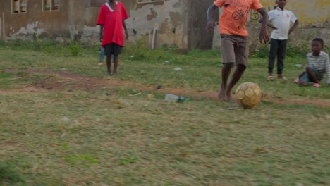 Dribbling-the-ball-bare-feet-and-he-amazingly-went-through-defenders-and-passes-the-ball,-community-football-pitch,-Kumasi,-Ghana