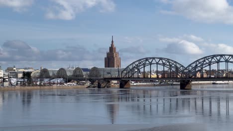 Fesselnde-4K-Aufnahmen-Der-Lettischen-Akademie-Der-Wissenschaften-Vor-Dem-Hintergrund-Des-Zugefrorenen-Flusses-Daugava-Und-Der-Altstadt-Von-Riga