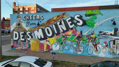 Colorful-mural:-Cheers-from-Des-Moines,-cyclists-and-cityscape