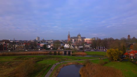 Drone-approaching-urban-city-Den-Bosch-over-rural-countryside-fields-and-canal