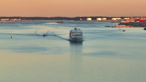 Kreuzfahrtschiff-Segelt-Bei-Sonnenuntergang-Mit-Kielwassermustern-Auf-Ruhigem-Meereswasser-Bei-Sonnenaufgang