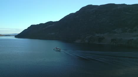 Pequeña-Isla-En-Un-Lago-Tranquilo-Con-Vuelo-Sobre-Un-Revelador-Ferry.