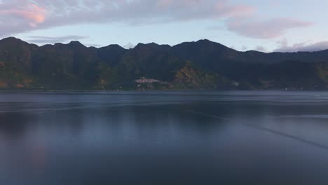 Wide-view-of-Lake-Atitlan-with-San-Marcos-on-background-during-sunrise,-aerial