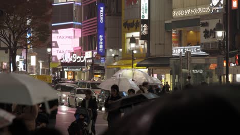 Shibuya-Cruzando-Peatones-Por-La-Noche-Durante-La-Lluvia,-Tokio,-Japón