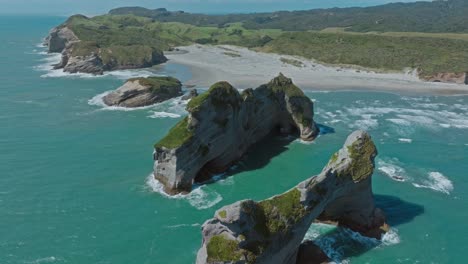 Stunning-aerial-drone-view-of-rugged,-rocky-outcrop-landscape-at-Wharariki-Beach,-Cape-Farewell,-South-Island-of-New-Zealand-Aotearoa