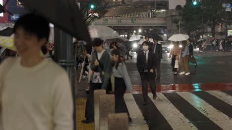 Shibuya-Cruzando-Peatones-Por-La-Noche-Durante-La-Lluvia,-Tokio,-Japón