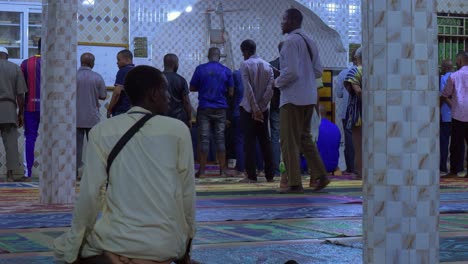 Un-Hombre-Arrodillado-Mira-A-Su-Alrededor-Mientras-La-Gente-Espera-Que-Comiencen-Las-Oraciones-En-La-Mezquita.