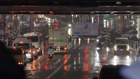 Peatones-De-Shibuya-Cruzando-La-Calle-Por-La-Noche-Durante-La-Lluvia,-Tokio,-Japón