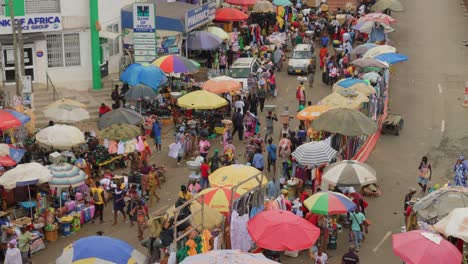 Car-drives-between-crowd-of-people-walking-past-vendors-in-Adum-market