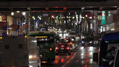 Peatones-De-Shibuya-Cruzando-La-Calle-Por-La-Noche-Durante-La-Lluvia,-Tokio,-Japón