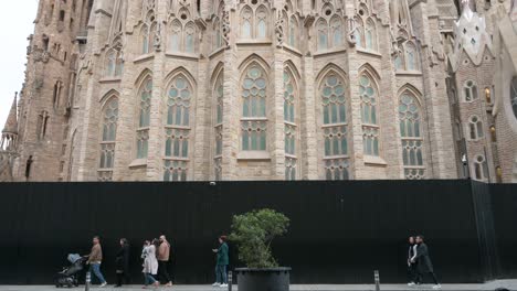 Turistas-Y-Peatones-Pasan-Por-La-Sagrada-Familia,-La-Iglesia-Católica-Inacabada-Más-Grande-Del-Mundo-Y-Parte-Del-Patrimonio-Mundial-De-La-Unesco.