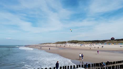 Drachenfliegen-Im-Wind-An-Einem-Von-Vielen-Menschen-Umgebenen-Strand-In-Den-Niederlanden