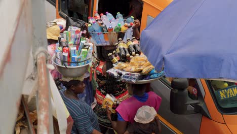 Teleaufnahme-Von-Afrikanischen-Frauen-Auf-Dem-Adum-Markt,-Die-Körbe-Mit-Snacks-Balancieren-Und-Sich-Unterhalten