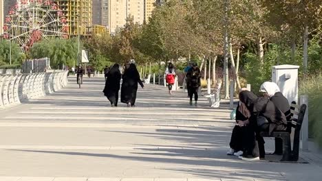 Friedlicher-Gemeinsamer-Abschied-Im-Iran,-Teheran,-Naher-Osten,-Asien.-Iranische-Frauen-Werden-Gezwungen,-Ein-Langes-Schwarzes-Hijab-Tschador-Kleid-Zu-Tragen,-Um-Kopf-Und-Körper-Zu-Bedecken,-Aber-Sie-Kämpfen-Für-Die-Freiheit,-Indem-Sie-Am-Frühen-Morgen-Im-Park-Spazieren-Gehen