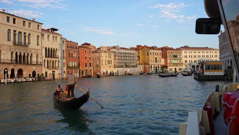 Gondolas-navigating-the-waters-of-the-Grand-Canal-in-Venice-at-sunset,-Italy