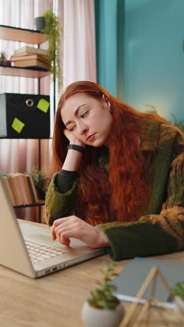 Bored-sleepy-business-woman-worker-working-on-laptop-computer-yawns-leaning-on-hand-at-office-desk