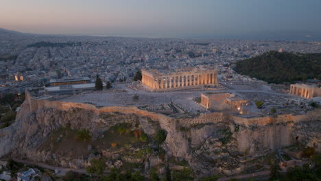 Absteigende-Schwenk-Luftaufnahme-Der-Beleuchteten-Akropolis-Von-Athen,-Griechenland