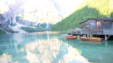 Hermosa-Mujer-Sonríe-Mirando-El-Lago-Di-Braies-Reflejando-Impresionantes-Dolomitas,-Italia