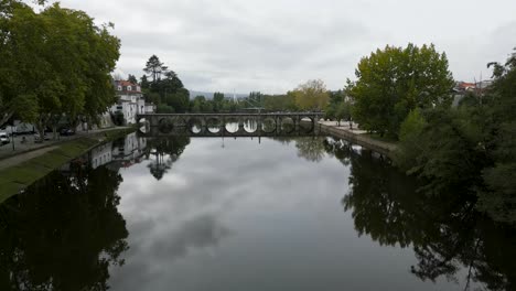 Drone-ascends-to-establish-roman-bridge-of-Aquae-Flaviae,-Chaves-Vila-Real-Portugal