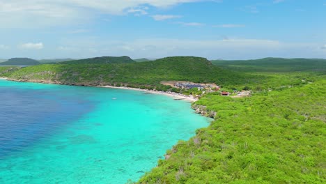Drone-flies-over-tropical-arid-landscape-of-Curacao-as-clouds-pass-on-Playa-Porto-Mari