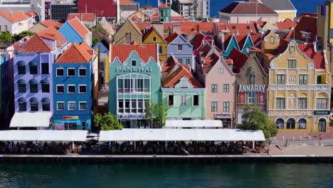 Drone-ascends-revealing-vibrant-buildings-of-Handelskade-Punda-District-Willemstad-Curacao