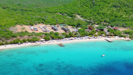 Drone-rises-tilting-down-showcasing-Playa-Porto-Mari-clear-Caribbean-water-in-Curacao