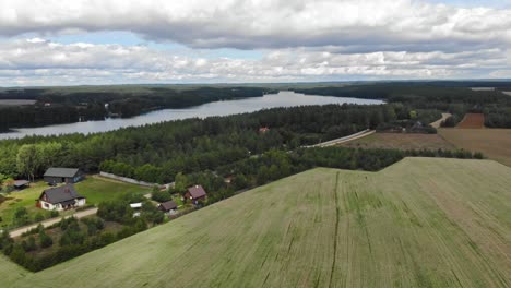 High-altitude-flight-over-Lake-Jezioro-Gwiazdy-and-Borowy-Młyn-village-in-Kaszuby,-Pomeranian-Voivodeship,-Poland