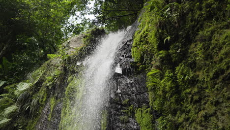 Slow-motion-tilting-shot-of-a-waterfall-in-the-Puerto-Rican-jungle