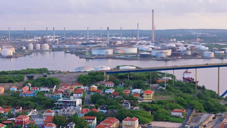 Trucking-pan-across-Queen-Juliana-Bridge,-Willemstad-Curacao-with-oil-refinery-behind