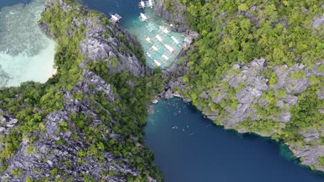 Panoramic-bird's-eye-aerial-of-tour-boats-and-people-at-Barracuda-lake,-Coron