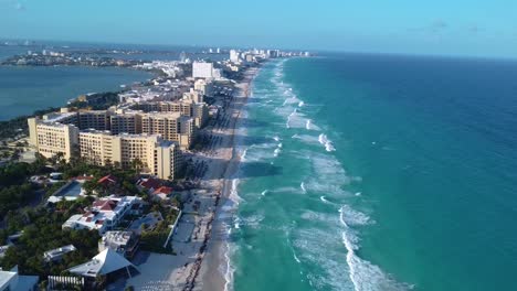 Wide-aerial-video-of-the-Cancun-hotels-zone,-Caribbean-sea,-luxury-hotel,-aerial-footage-of-turquoise-blue-water-and-waves-crashing