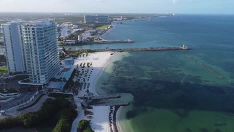 Aerial-footage-of-Puerto-Cancun-beach-area,-aerial-of-hotels-on-the-oceanfront-with-clear-blue-ocean-waters