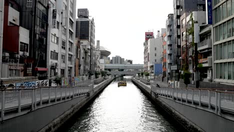 Tombori-River-Cruise-Sailing-Along-Dotonbori-Canal-In-The-Distance-In-The-Afternoon
