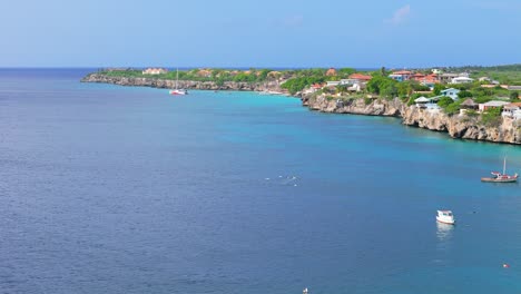 Aerial-orbit-around-Playa-kalki-and-catamaran-in-distance,-Westpunt-Curacao