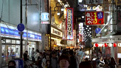 Multitudes-De-Personas-Caminando-Por-La-Zona-De-Shinsekai-Por-La-Noche-Pasando-Por-La-Tienda-Lawsons