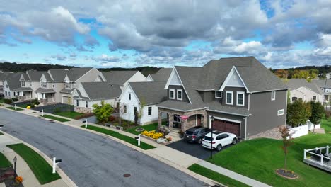 Suburban-street-with-uniform-houses,-manicured-lawns,-and-cloudy-skies