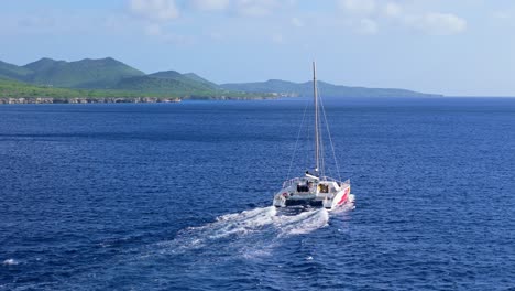 Aerial-orbit-around-catamaran-off-coast-of-Caribbean-island-in-Westpunt,-Curacao