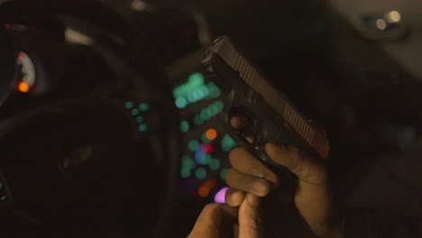 close-up-of-a-black-man-inserting-a-loaded-clip-into-his-handgun-and-cocking-it-to-load-a-bullet-in-the-chamber