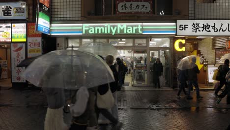 People-in-front-of-Family-Mart-Convenience-Store-in-Shibuya-at-Night,-Tokyo,-Japan