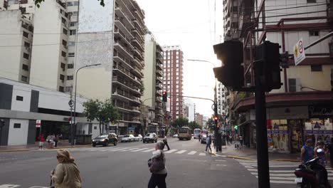 Rivadavia-Avenue-Verkehr-In-Der-Nachbarschaft-Von-Flores-Menschen-Gehen-Im-Frühling-In-Die-Stadt-Buenos-Aires,-Argentinien