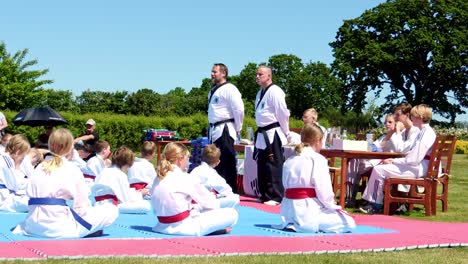 Dos-Instructores-De-Taekwondo-Hablan-Con-Jóvenes-Estudiantes-De-Taekwondo-Durante-La-Ceremonia-Del-Nuevo-Cinturón.